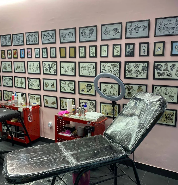 Interior da Garoa Tattoo com maca e artes emolduradas